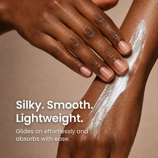 Close-up of a hand applying antioxidant cream onto another hand, with text reading 'Silky. Smooth.