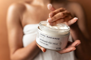 Woman holding a jar of Shea Radiance antioxidant body cream with a blurred background
