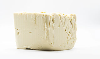 Block of white cheese on a white background
