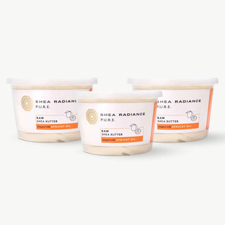 Three containers of apricot large Shea Radiance raw shea butter on a white background