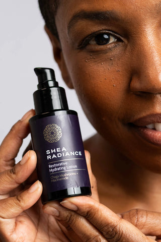 Person holding a Shea Radiance skincare bottle against a neutral background